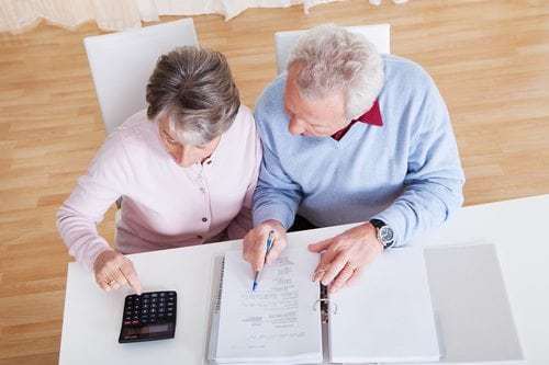 Senior Couple Calculating Budget At Home