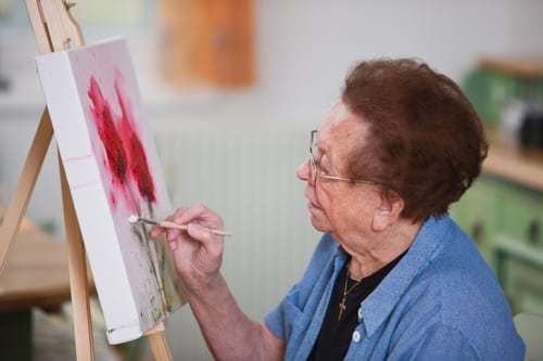 senior woman paints a picture