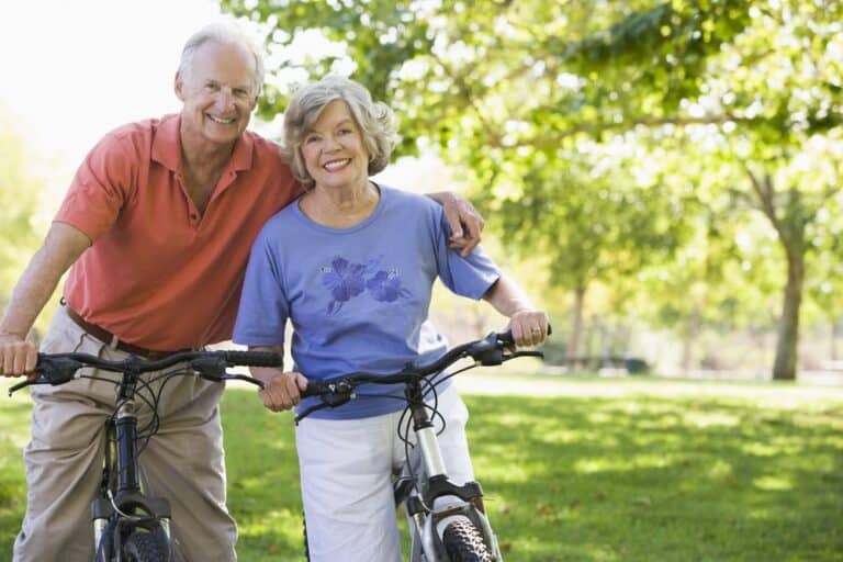 Smiling-senior-couple-bicycling-in-a-park