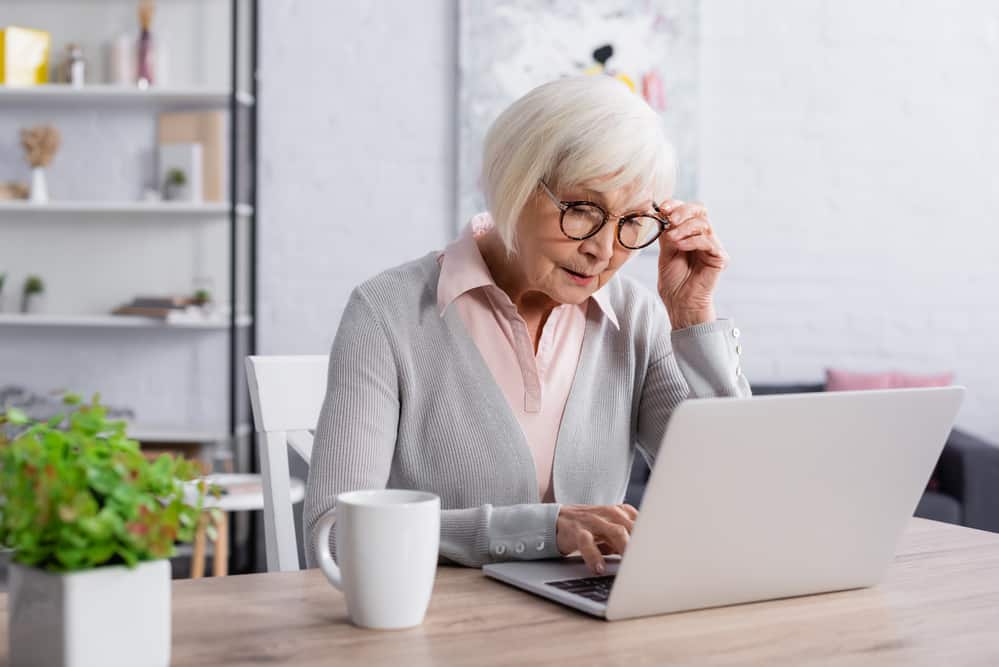 Senior woman looking at laptop while seated at desk