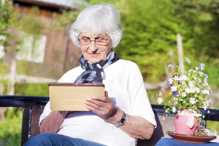 Senior woman looking at tablet outside in spring