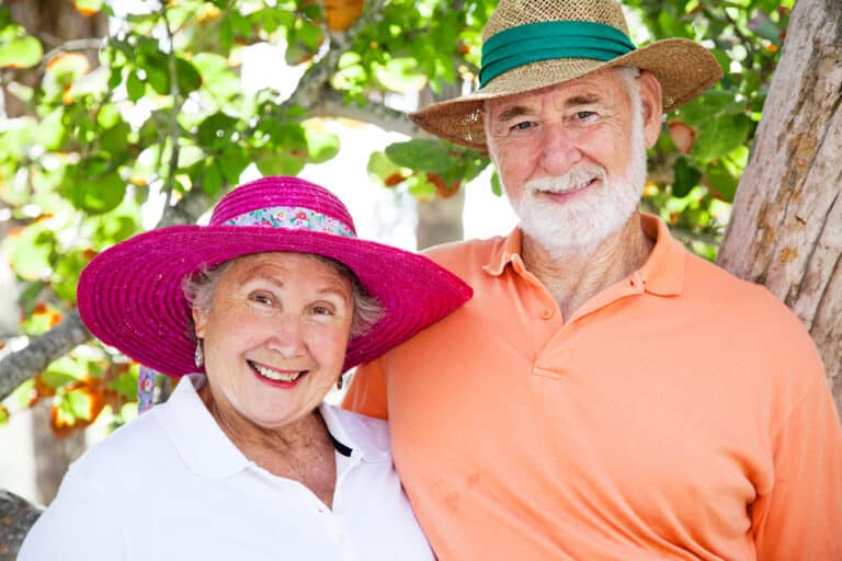 Senior couple wearing sun hats outside