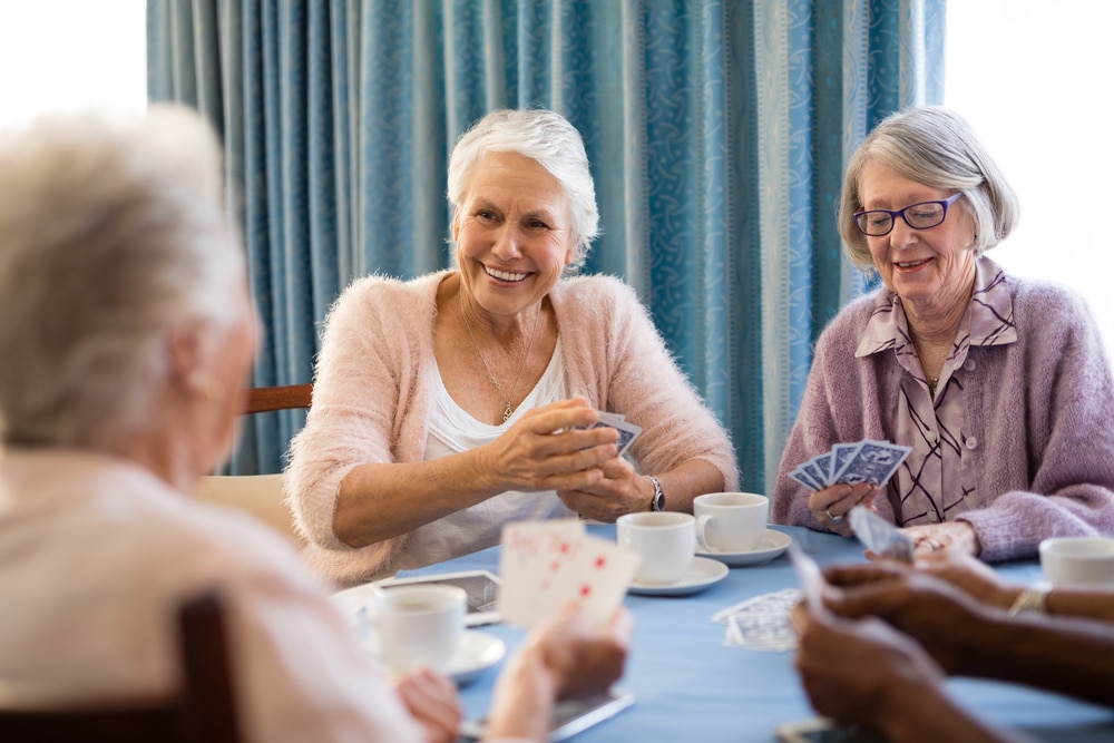 Seniors smiling and playing cards