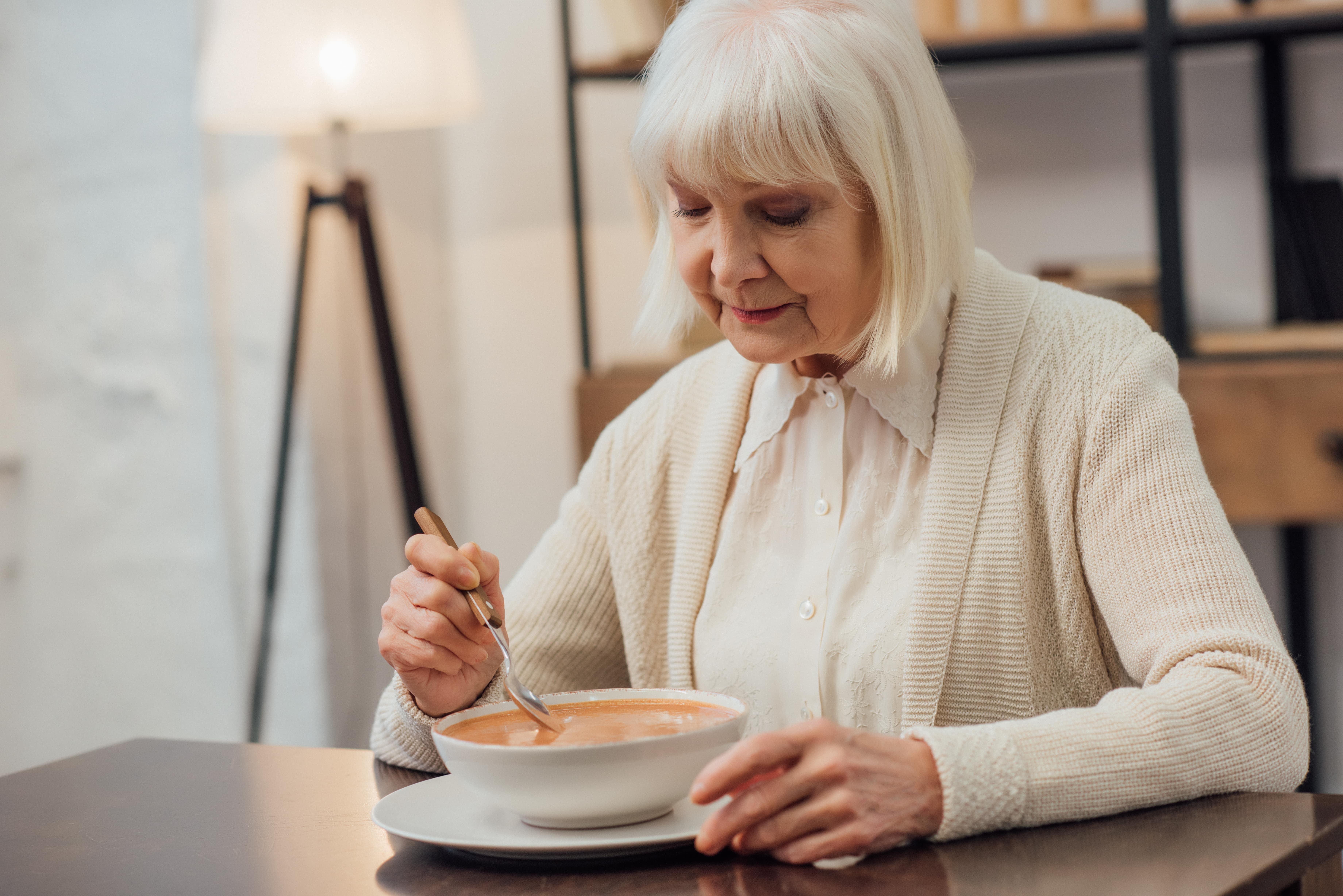senior woman eating soup
