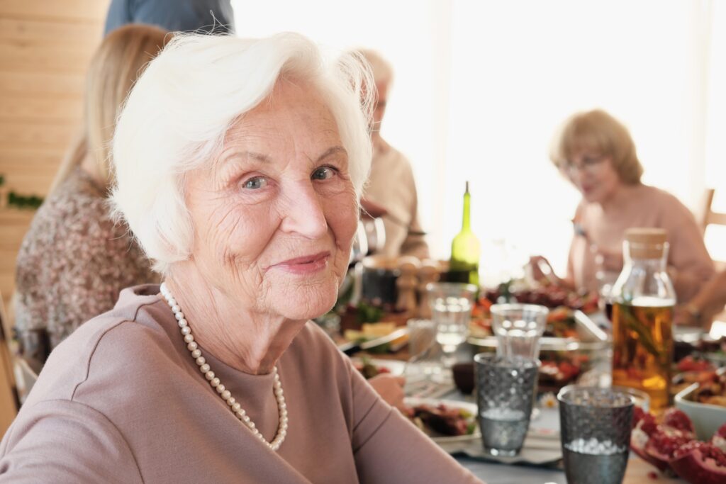 Senior woman smiling while dining out with friends