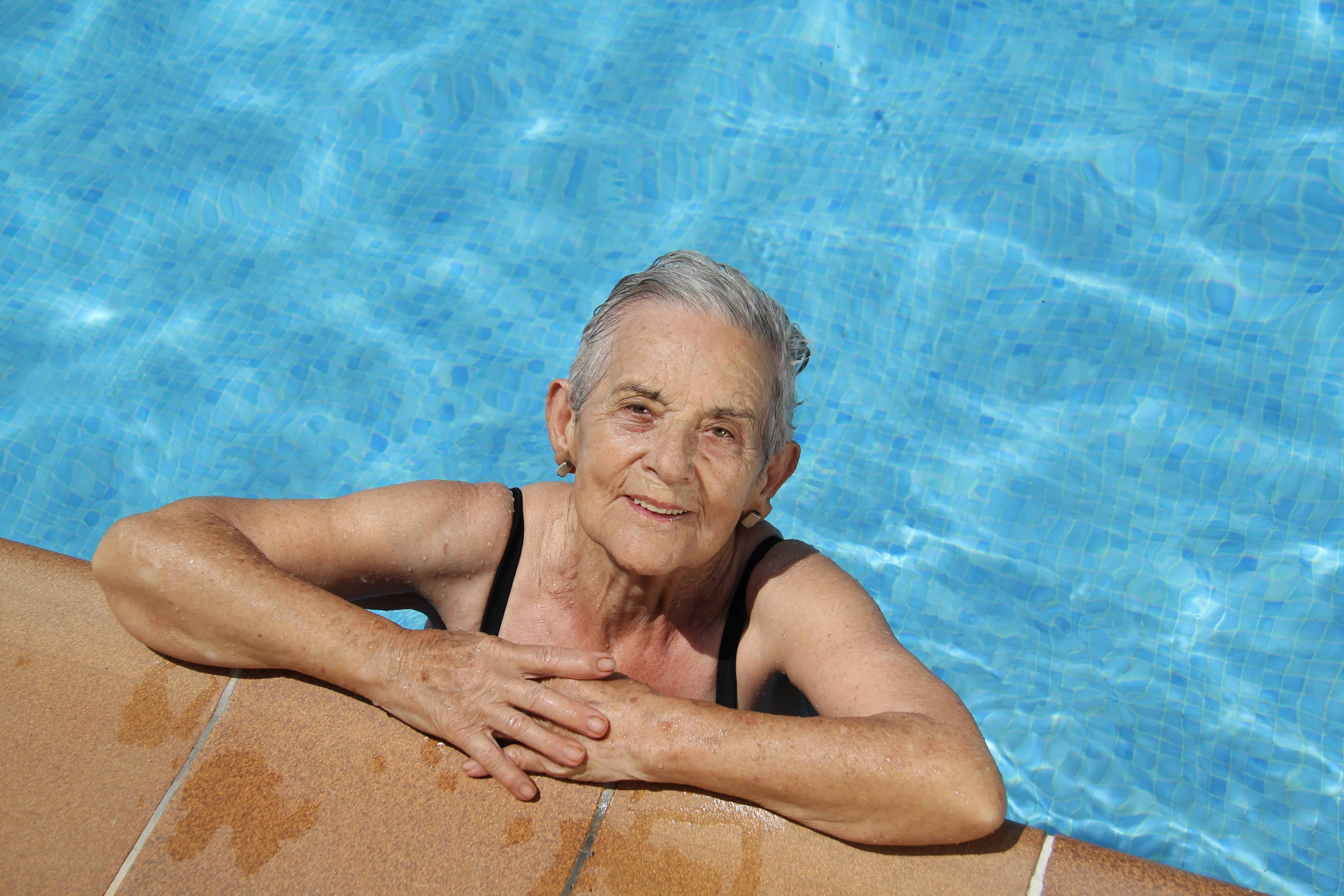 Smiling senior woman in pool swimming