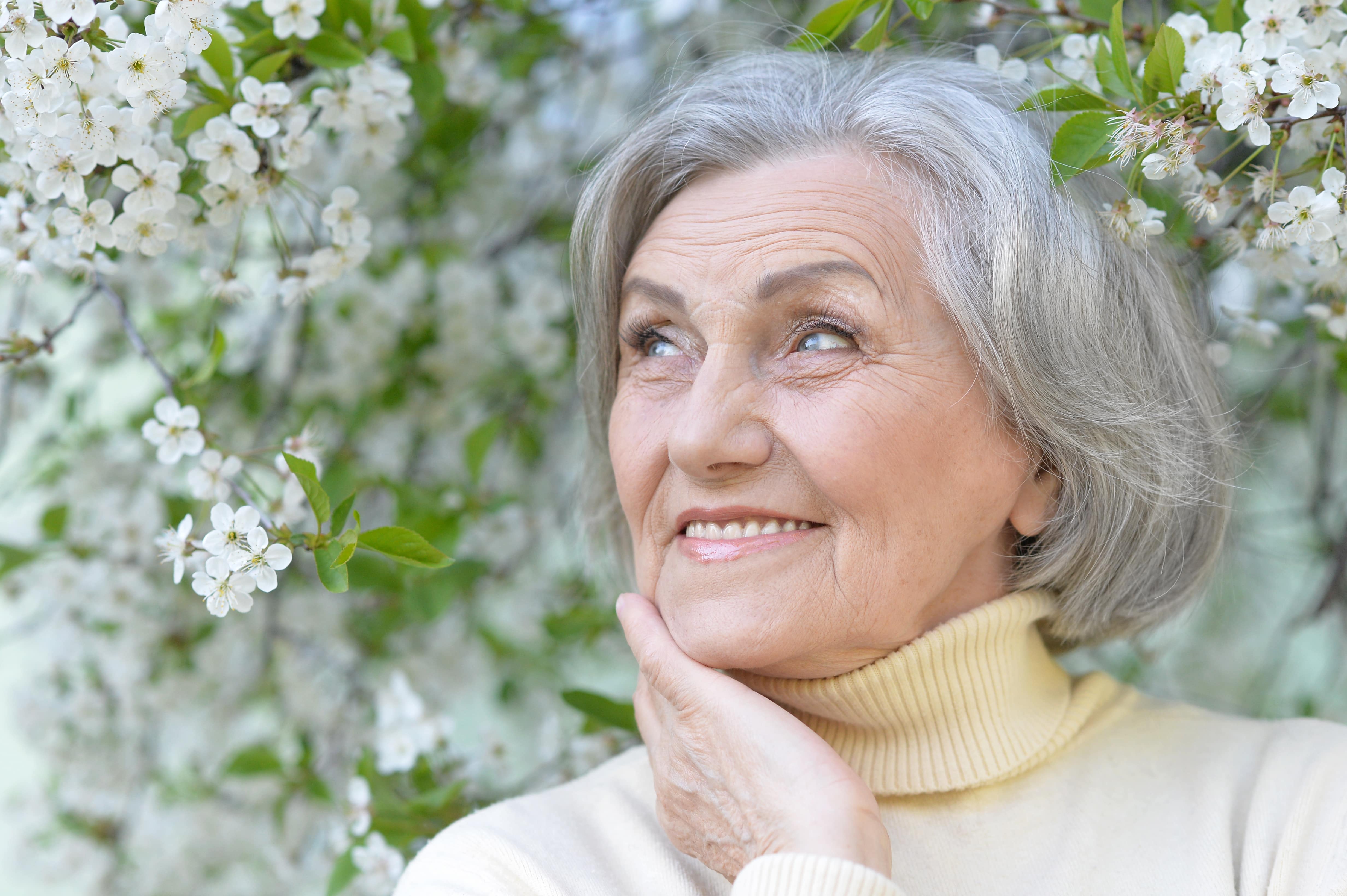 Portrait of senior woman outside by spring flowers